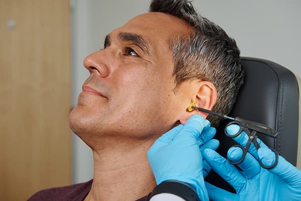 Boston Audiologist fits a hearing aid
