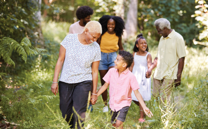 Senior black woman walking with grandson and family in woods