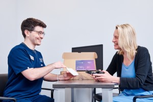 Audiologist showing patient Lenire product image