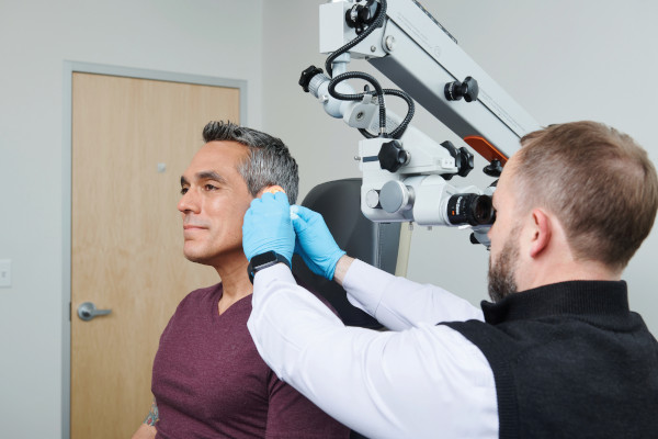 A patient receiving a hearing cleaning at Tobias And Battite Hearing Wellness